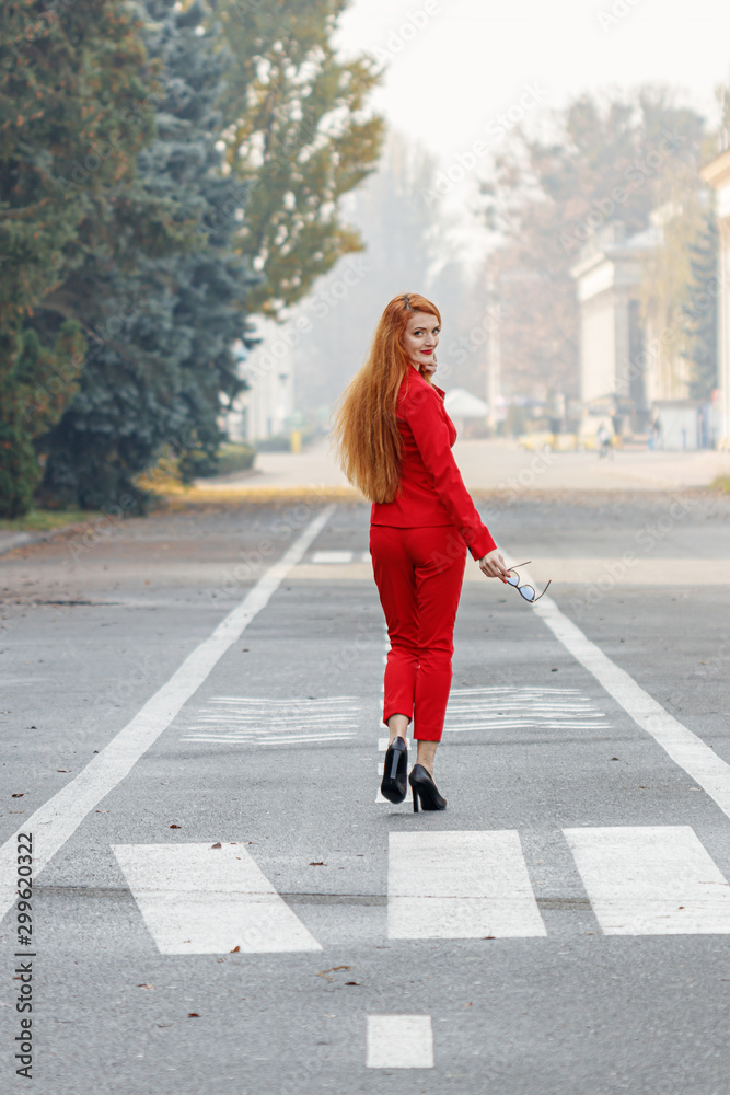 beautiful girl with red hair dressed in a red business suit. Business portrait. beautiful girl with red hair dressed in a red business suit. Business portrait.