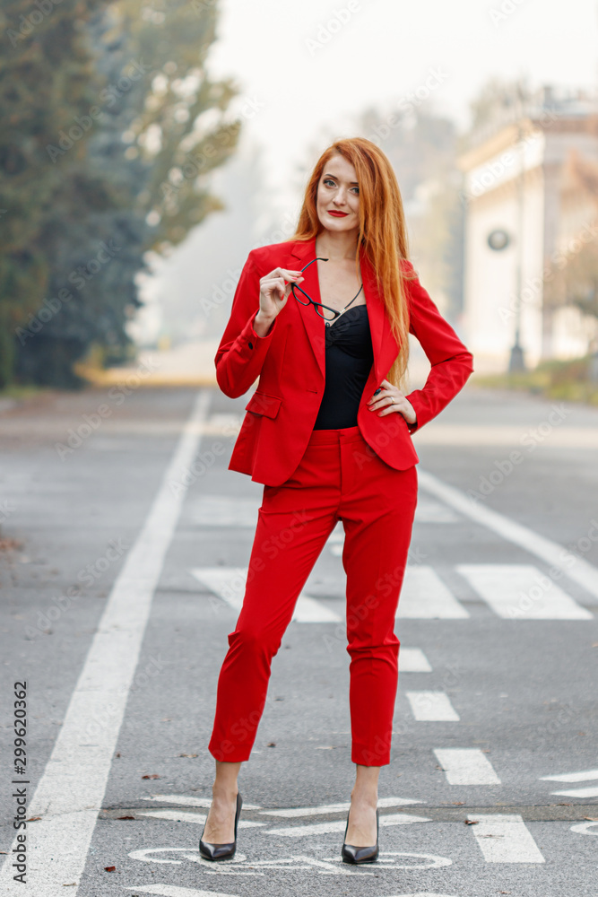 beautiful girl with red hair dressed in a red business suit. Business  portrait. Stock Photo | Adobe Stock