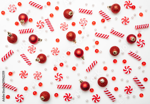 Xmas baubles and candies flat lay against white background