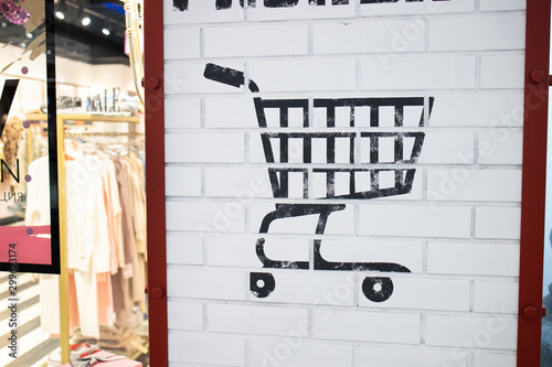 Grocery trolley. Symbol of retail. Shopping cart sign on the wall of big shopping center. photo