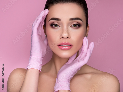 Cosmetology treatment on a brunette caucasian woman face. Fresh, clean skin with flawless features. She holds cosmetology items in her hands photo