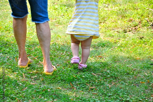 A toddler and an older woman take some first steps together.