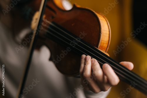 Close-up of a beautiful violin played by girl. Beautiful young woman musician playing the violin