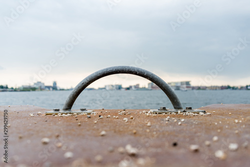 skyline of Amsterdam through a small rounded handle on the kay wall with l;ots of empty space in the grey sky