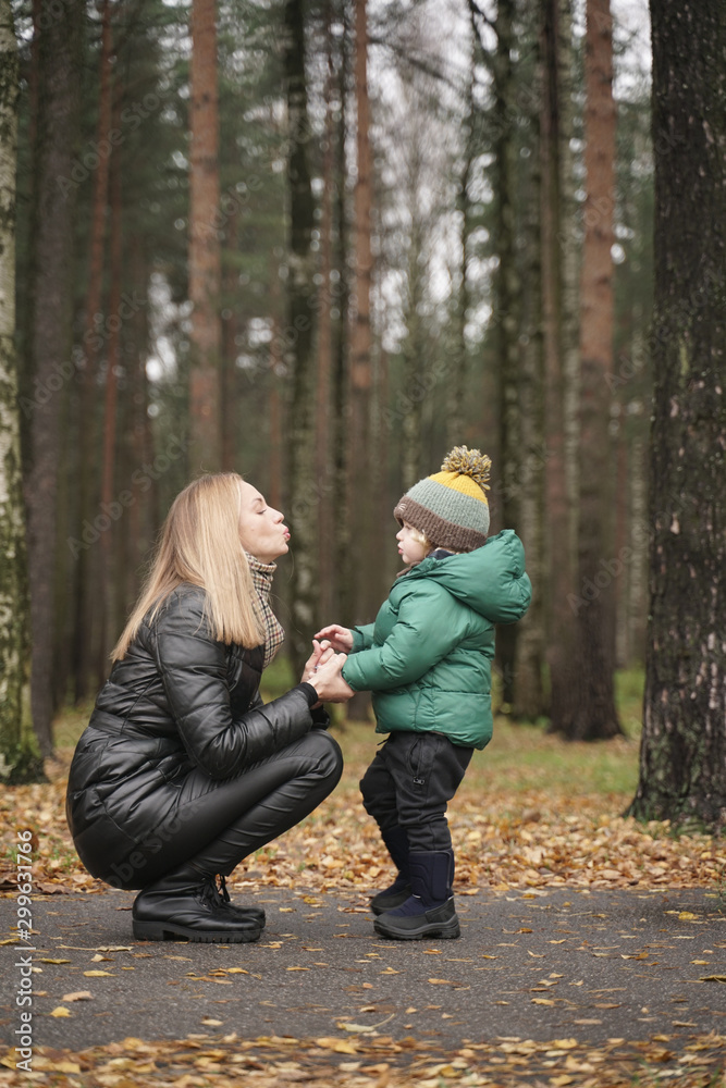 beautiful Caucasian mother and little child having fun in autumn Park, walking. beautiful Caucasian mother and little child having fun in autumn Park, walking.