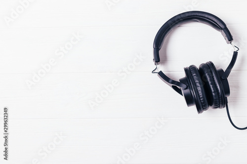 Black headphones on white wooden background