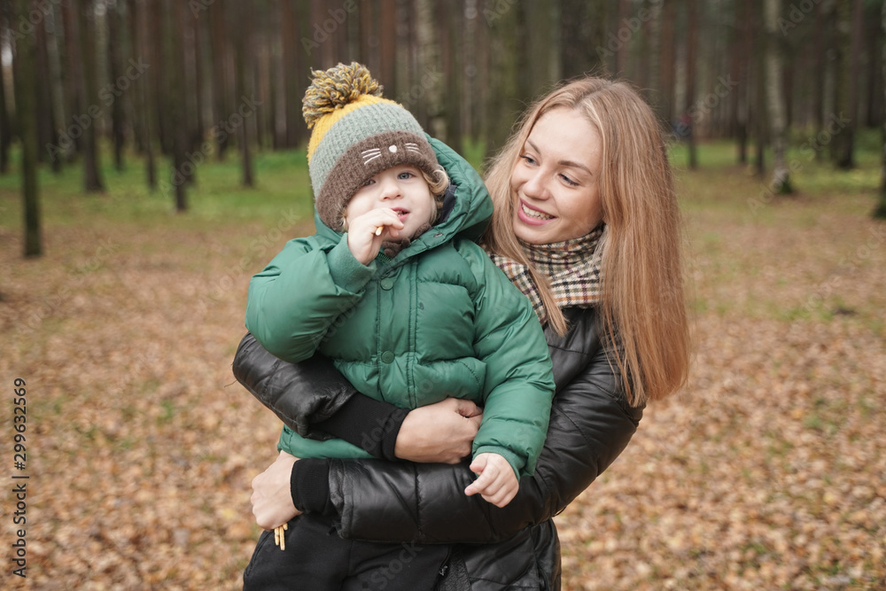 caucasian young mother and little child having fun in autumn Park, walking caucasian young mother and little child having fun in autumn Park, walking