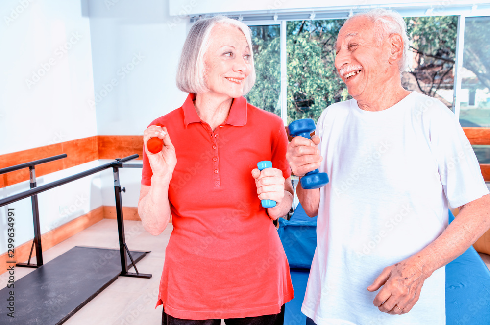 Senior retired elderly people in sports clothing in gym, working out with the help of trainer Senior retired elderly people in sports clothing in gym, working out with the help of trainer