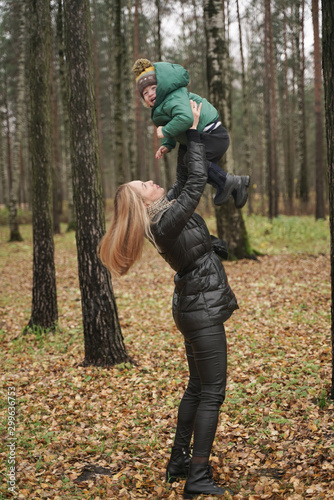 caucasian young mother and little child having fun in autumn Park, walking