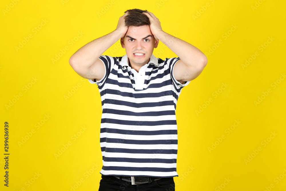Young angry man on yellow background Young angry man on yellow background