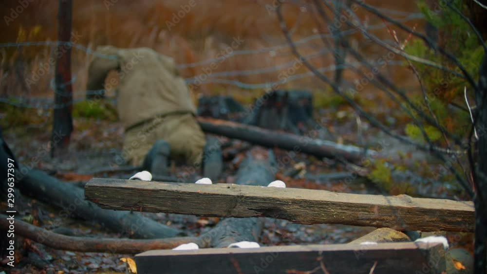 Dead soldier lying on the iron wire - piece of log on a foreground Dead soldier lying on the iron wire - piece of log on a foreground