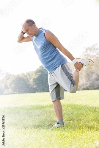 Full length of senior man exercising in park
