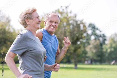 Happy senior man looking at woman while jogging in park