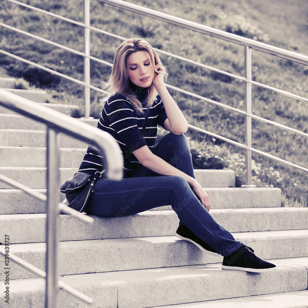 Young fashion woman in striped turtleneck t-shirt sitting on the steps Young fashion woman in striped turtleneck t-shirt sitting on the steps