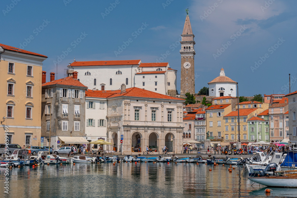 Venetian Port and the Main Square Tartini of Piran city reflected on water, Slovenia.