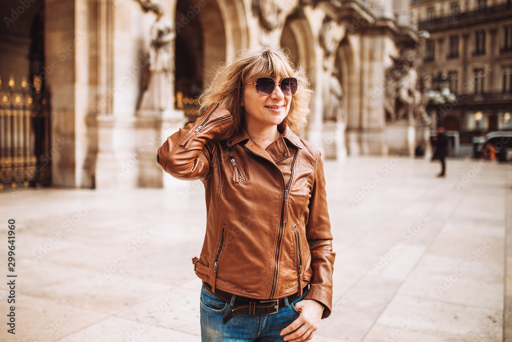 Fototapeta premium Attractive blonde in casual clothes on a walk among urban architecture