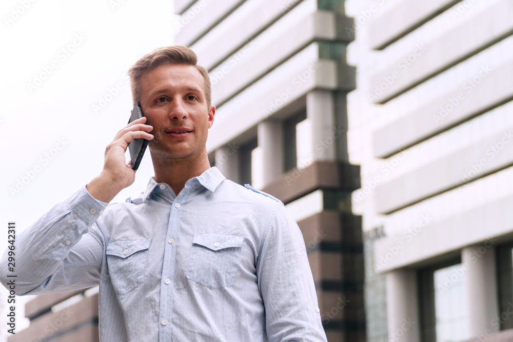 Freelance handsome young man talking about plan work with smartphone while walking in urban street. Businessman using mobile phone talk about job at outside office. Freelance handsome young man talking about plan work with smartphone while walking in urban street. Businessman using mobile phone talk about job at outside office.