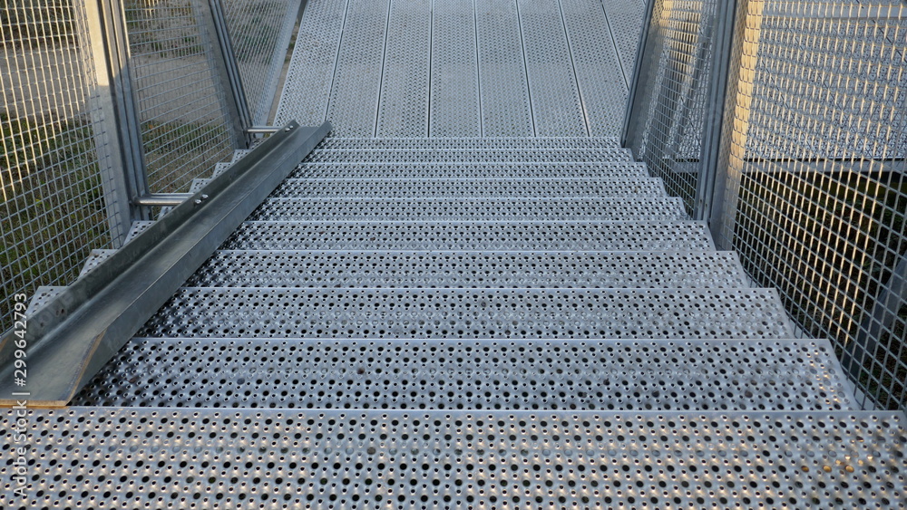 Fototapeta premium Grate steel staircase. External staircase with rail for bicycles on a cliff in Hohwacht, Schleswig-Holstein, Germany