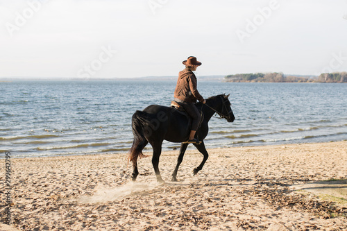 Free independent purposeful girl riding a horse rides along the seashore