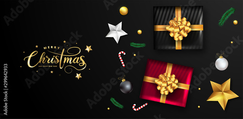 Merry Christmas and Happy New Year greeting card design with top view of baubles  gift box  stars and lighting garland decoration on black background.