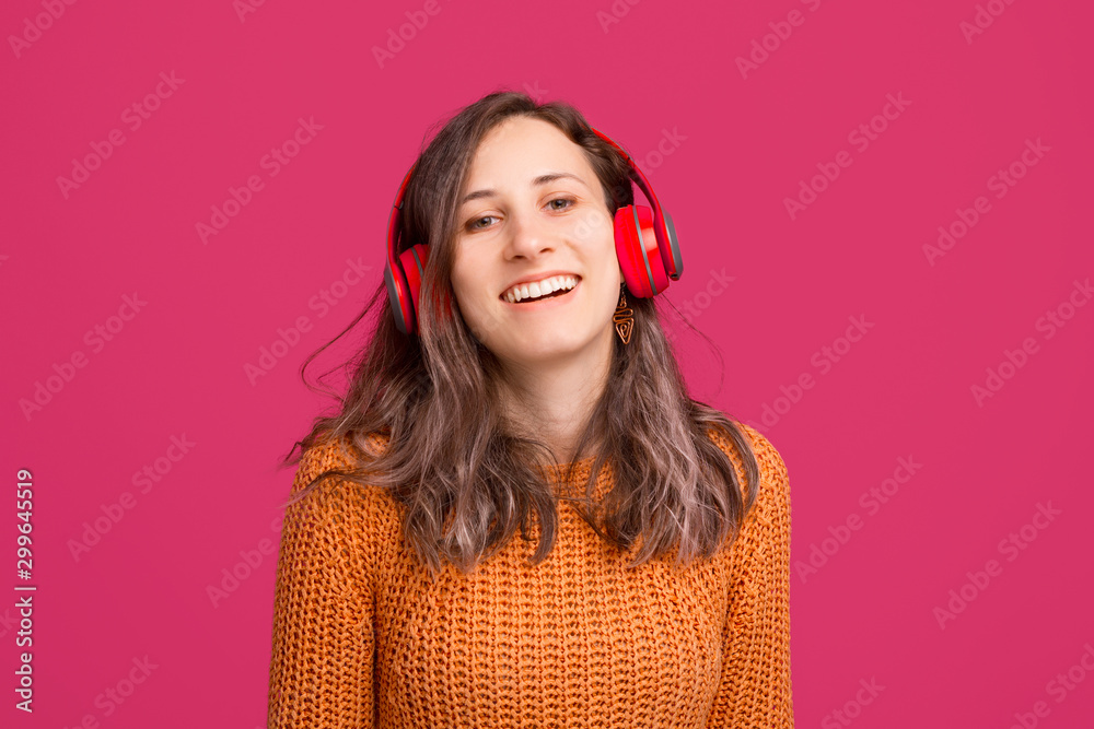 Photo of cheerful young woman wearing yellow sweater and listening music at headphones Photo of cheerful young woman wearing yellow sweater and listening music at headphones