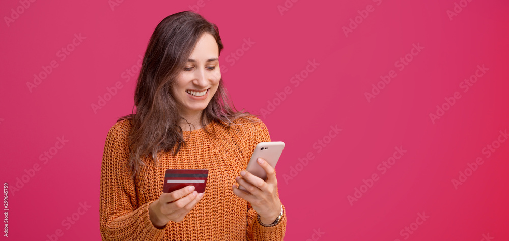 Cheerful young woman using his smartphone and holding credit card, mobile web banking Cheerful young woman using his smartphone and holding credit card, mobile web banking