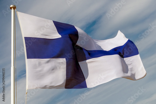 the flag of the Republic of Finland in the form of a blue cross on a white cloth, the pattern of Finland proudly evolving in the wind Fototapet