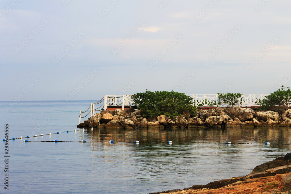 Looking along the coastline and out over the Caribbean sea, Ocho Rios, Jamaica. Early morning light, cloudy sky. Looking along the coastline and out over the Caribbean sea, Ocho Rios, Jamaica. Early morning light, cloudy sky.