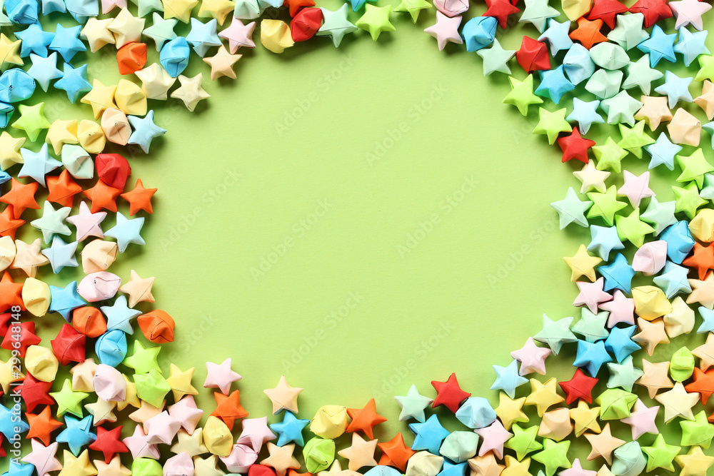 Colorful paper stars on green background