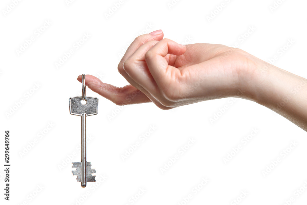 Female hand holding house key on white background Female hand holding house key on white background