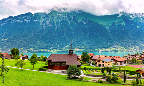 Panoramic view of swiss village Iseltwald with traditional wood church on the southern shore of Lake Brienz, Switzerland