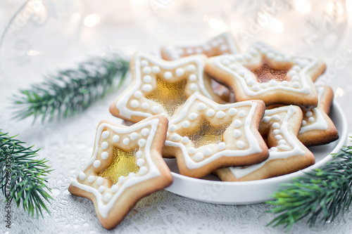 Homemade Christmas star shape sugar caramel cookies on white background with fir-tree branches