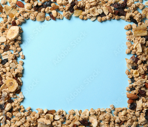 Frame made of ingredients for homemade healthy granola bars on blue background, flat lay. Space for text