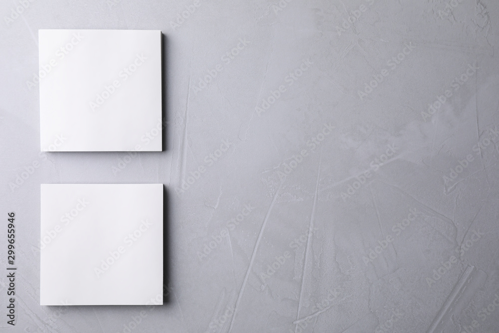 Fototapeta premium Blank note papers on light grey background, flat lay. Mock up for design