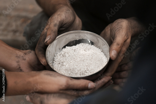Fotografie, Obraz Poor homeless people with bowl of rice outdoors, closeup