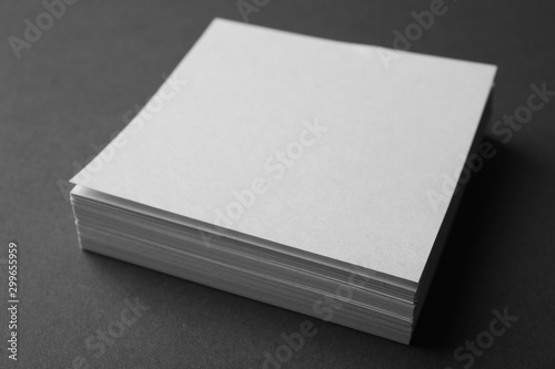 Blank note papers on dark grey background, closeup. Mock up for design
