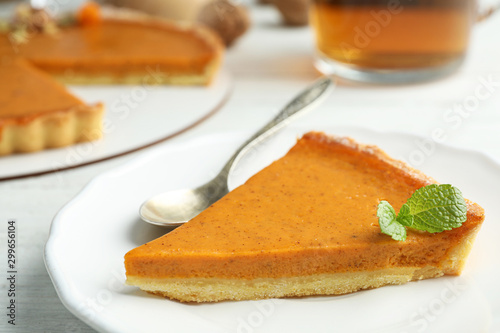 Piece of delicious fresh homemade pumpkin pie on white wooden table, closeup