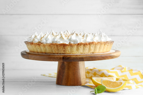 Stand with delicious lemon meringue pie on white wooden table