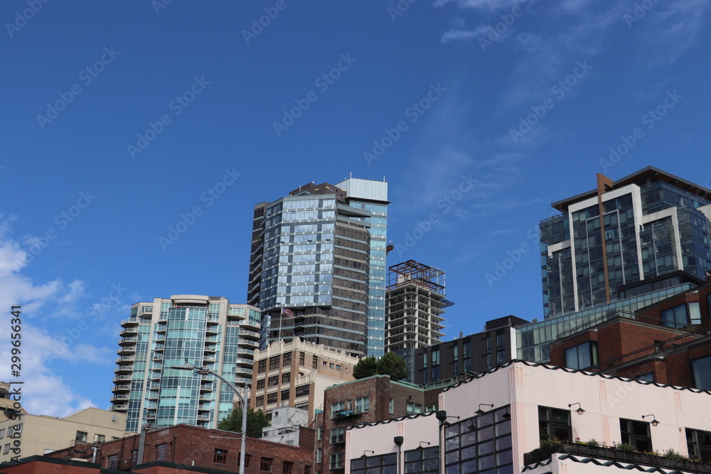 glass towers and brick low-rises with blue sky and cloud