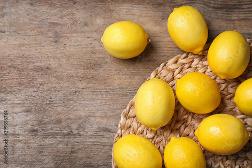 Fresh lemons on wooden table, flat lay. Space for text