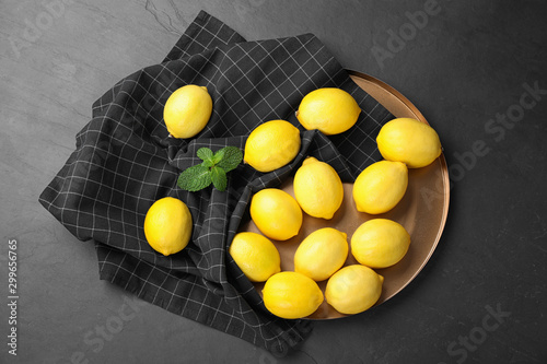 Flat lay composition with fresh ripe lemons on dark table