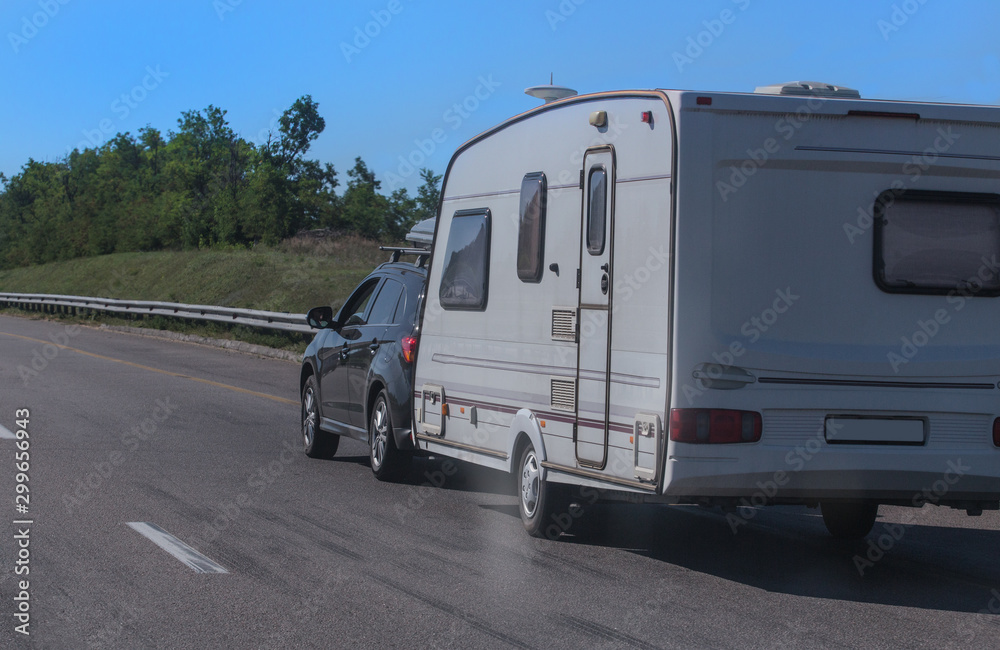 SUV with a camping trailer is moving along the road