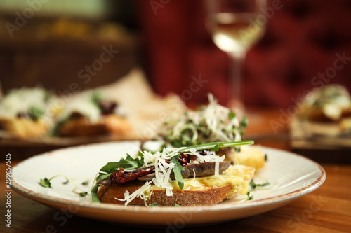 Plate with delicious bruschettas on wooden table, closeup