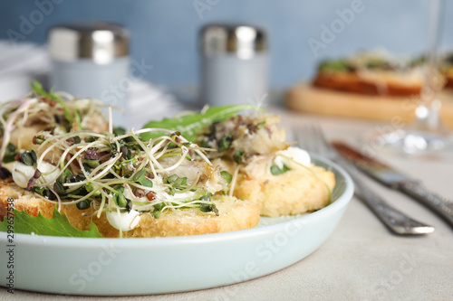 Delicious bruschettas with fish on light table, closeup