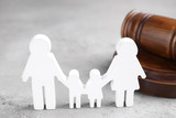 Figure in shape of people and wooden gavel on grey table. Family law concept