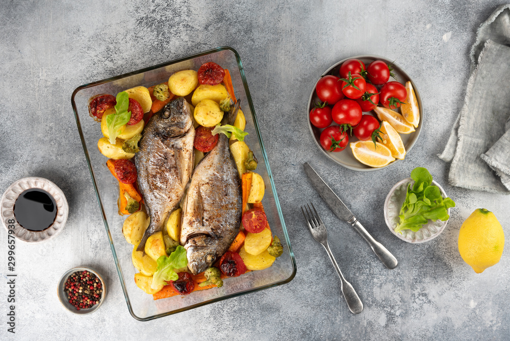 Baked dorado (dorada) fish on a plate, top view