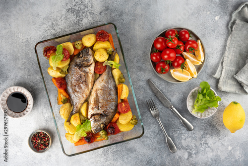 Obraz na płótnie Baked dorado (dorada) fish on a plate, top view w salonie