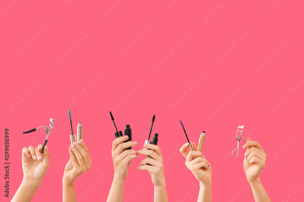 Many hands with mascara and eyelash curlers on color background Many hands with mascara and eyelash curlers on color background