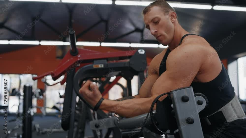 Exercise for the biceps. Bodybuilder young man hard training biceps muscles in gym Exercise for the biceps. Bodybuilder young man hard training biceps muscles in gym