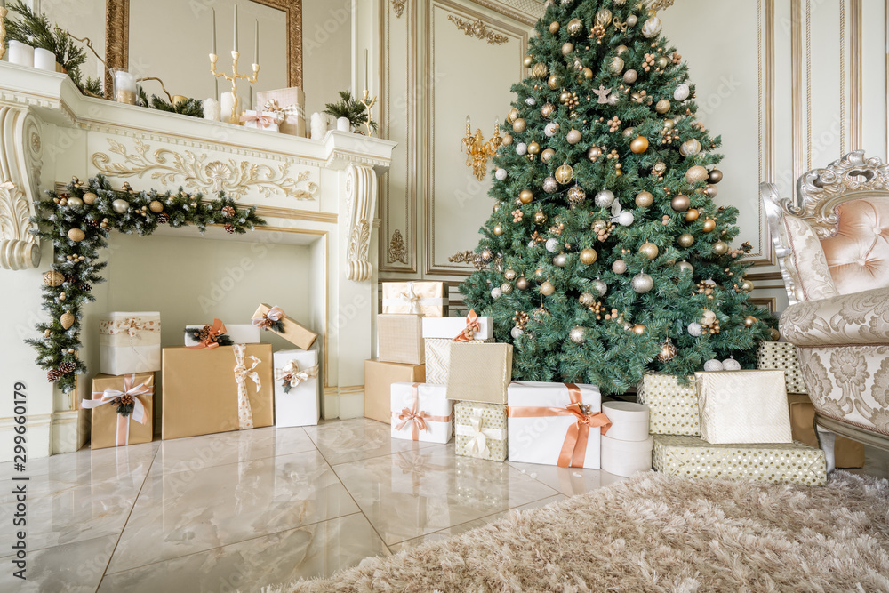 Obraz premium Christmas morning. Classic luxurious apartments with decorated christmas tree and presents. Living with fireplace, columns and stucco.